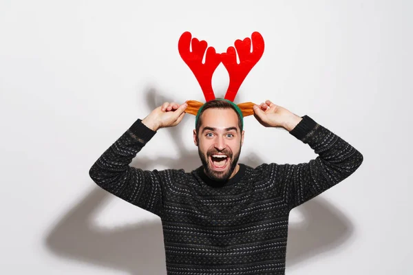 Image of man in Christmas reindeer antlers headband smiling and — 스톡 사진