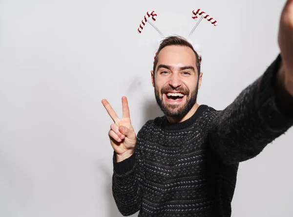 Image of man in Christmas candy cane headband gesturing peace fi — 스톡 사진