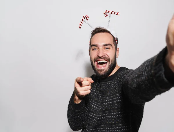 Image of man in Christmas candy cane headband pointing finger at — 스톡 사진