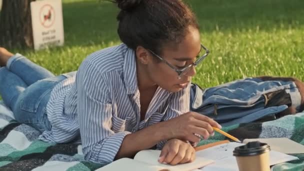 Geconcentreerde Mooie Afrikaanse Vrouw Bril Studeren Met Boek Terwijl Liggen — Stockvideo