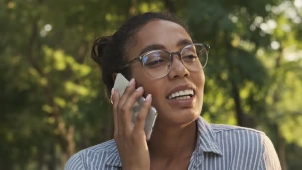 Veselý Pěkný Africký Žena Brýlích Mluvit Smartphone Zatímco Sedí Parku — Stock video
