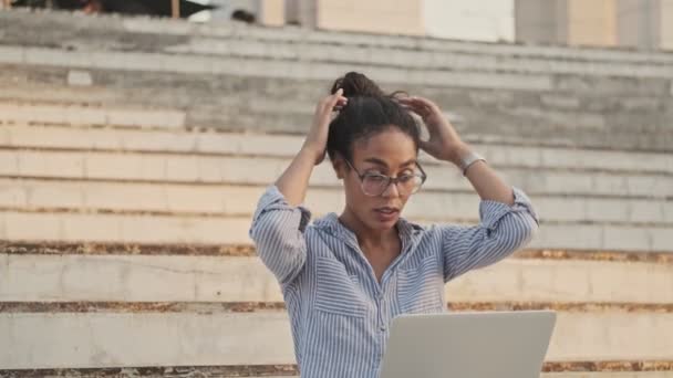 Mujer Africana Bastante Concentrada Gafas Usando Computadora Portátil Mientras Está — Vídeo de stock