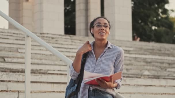 Lugn Vacker Afrikansk Kvinna Glasögon Och Hörlurar Studerar Med Anteckningsbok — Stockvideo