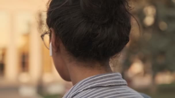 Крупный План Счастливой Африканской Женщины Очках Наушниках Разворачивающейся Оглядывающейся Парку — стоковое видео