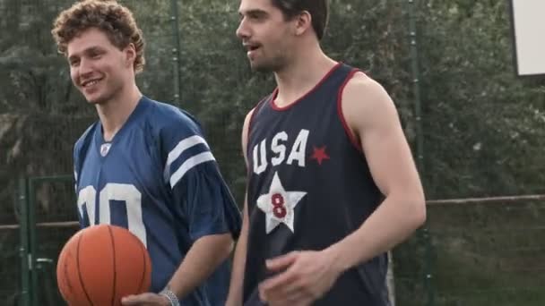 Vista Lateral Jugadores Baloncesto Guapos Felices Hablando Entre Mientras Caminan — Vídeo de stock