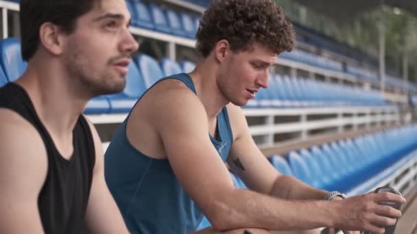 Oldalnézet Jóképű Kosárlabda Játékosok Pihentető Félrenéz Miközben Stadionban — Stock videók