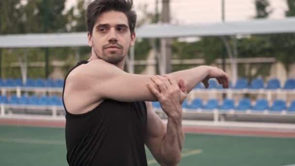 Enfocado Hombre Guapo Estirándose Con Las Manos Mirando Hacia Otro — Vídeos de Stock