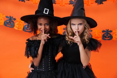 Image of multinational pretty girls showing silence gesture