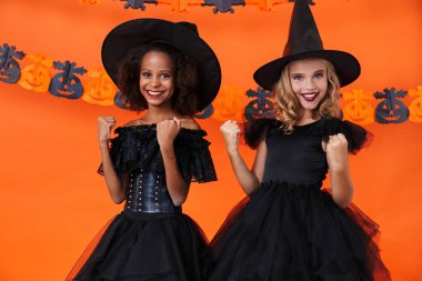 Image of happy multinational girls smiling with throwing up fists