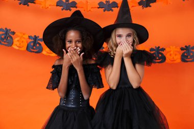 Image of pretty multinational girls laughing and covering their mouths