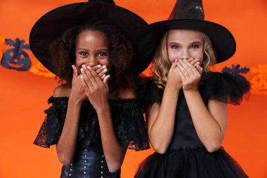 Image of cute multinational girls laughing and covering their mouths