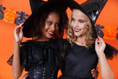 Image of lovely witch girls smiling and hugging together