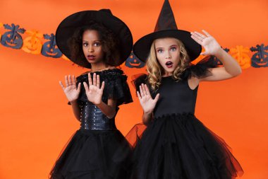 Image of frightened girls looking at camera and showing stop gesture