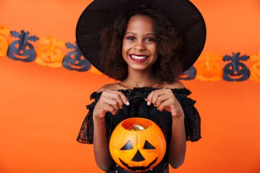 Image of happy african american girl holding toy pumpkin