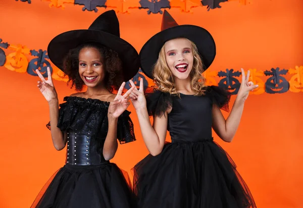 Imagen de chicas brujas sonriendo y haciendo gestos signo de paz —  Fotos de Stock