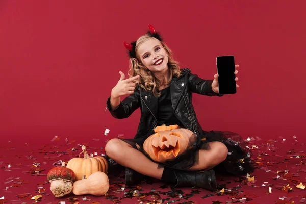 Devil in carnival halloween costume showing display of phone. — Stockfoto