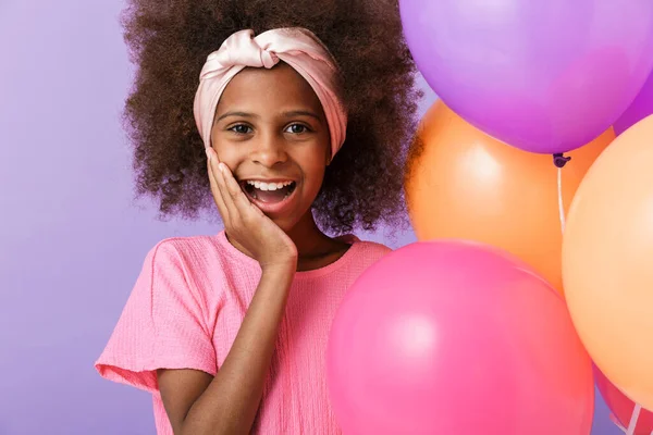 Feliz niña africana joven sobre fondo de pared púrpura . — Foto de Stock