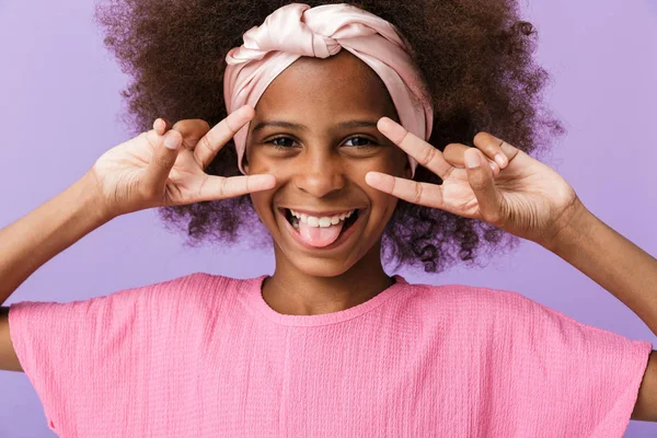 Optymistycznie nastawiona młoda afrykańska dziewczyna pokazuje gest pokoju. — Zdjęcie stockowe