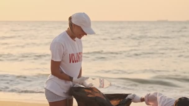 Усміхнені Захоплені Екологічні Волонтери Прибирають Пляж Пластику Сміттєвими Пакетами Узбережжі — стокове відео