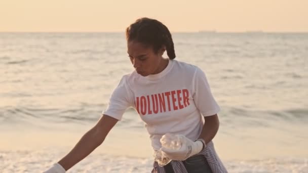 清晨时分 身穿白色T恤衫的受试者们正在海边用塑料袋清洗海滩 — 图库视频影像
