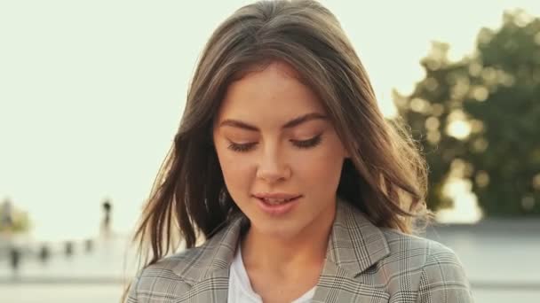 Ceket Giyen Dalgın Güzel Bir Kadın Dışarıda Yürürken Aşağıya Bakıyor — Stok video
