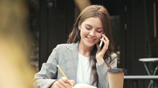 Una Joven Muy Sonriente Está Escribiendo Algo Mientras Recibe Una — Vídeo de stock