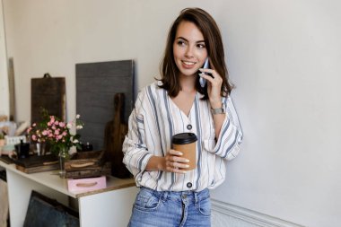 Attractive smiling young girl leaning on a wall