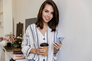 Attractive smiling young girl leaning on a wall