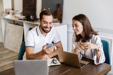 Smiling young couple working on a project