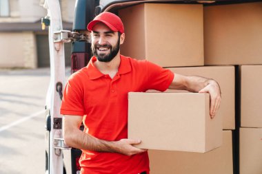 Paket posta kutusuyla duran mutlu teslimatçı.