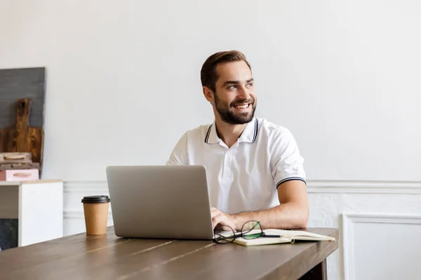 Knappe jonge bebaarde man aan tafel thuis — Stockfoto