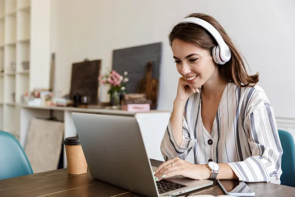 Schönes junges Mädchen sitzt zu Hause am Tisch — Stockfoto