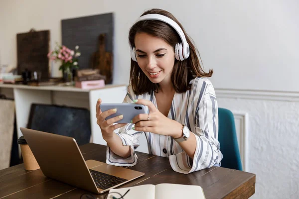 Schönes junges Mädchen sitzt zu Hause am Tisch — Stockfoto