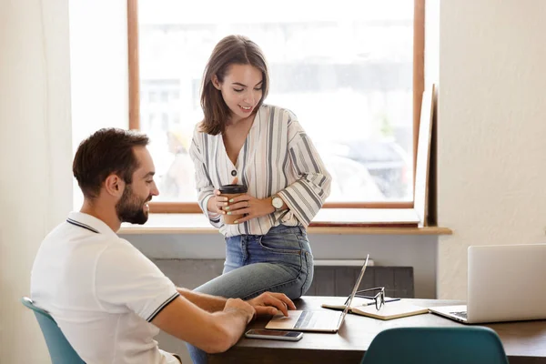 Lächelndes junges Paar bei der Arbeit an einem Projekt — Stockfoto