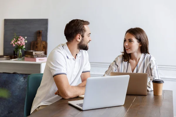 Smiling young couple working on a project — 스톡 사진