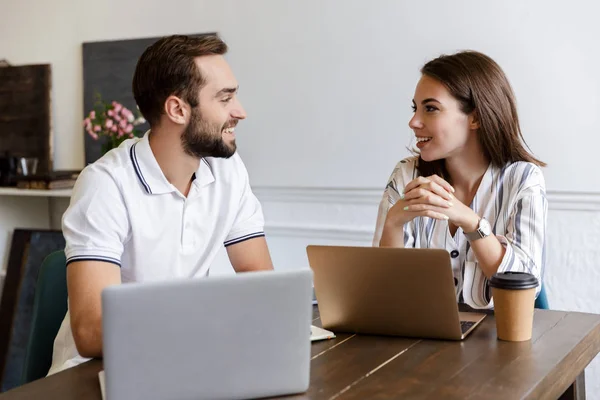 Lächelndes junges Paar bei der Arbeit an einem Projekt — Stockfoto