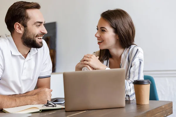 Smiling young couple working on a project — 스톡 사진