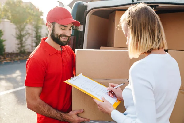 Beeld van vrolijke levering man geven orde aan Kaukasische vrouw — Stockfoto