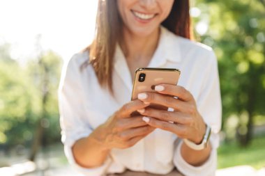 Mutlu ve çekici genç bir kadın bankta dinleniyor.