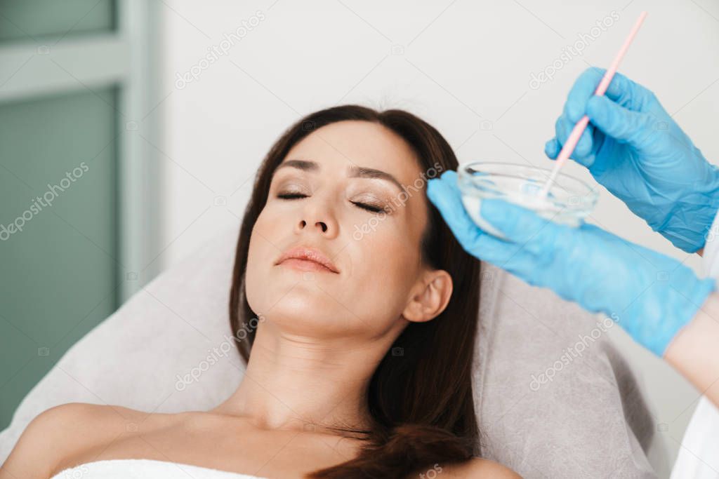 Photo of relaxed caucasian woman getting cosmetic procedure