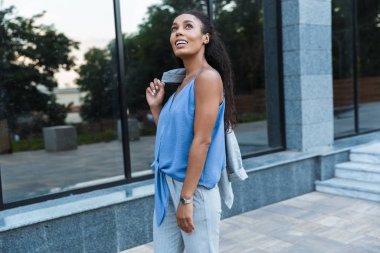 Çekici gülümseyen Afrikalı iş kadını dışarıda yürüyor.