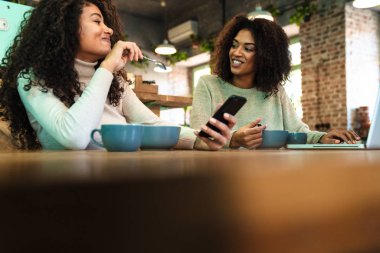 Kafede oturan iki mutlu Afrikalı kız arkadaşa yakın durun.