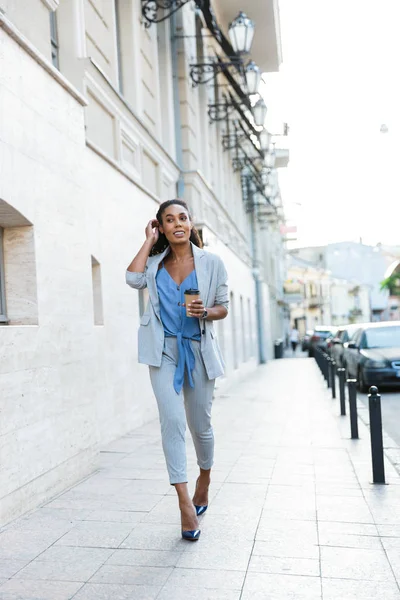 Attractive smiling african business woman walking outdoors — 스톡 사진