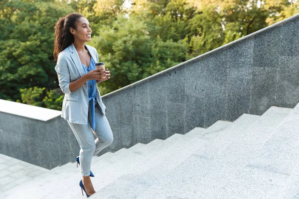 Atractiva sonriente mujer de negocios africana caminando — Foto de Stock