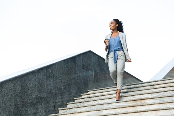 Attractive smiling african business woman walking down — Stock Photo, Image