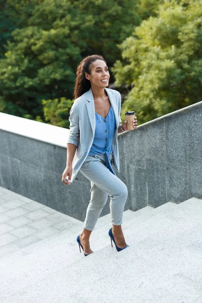 Attractive smiling african business woman walking up — 스톡 사진