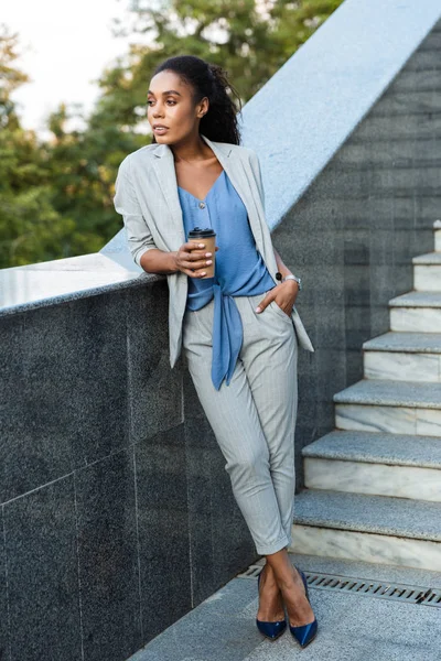 Atractiva mujer de negocios africana sonriente caminando al aire libre — Foto de Stock