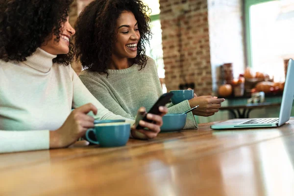 Gros plan de deux petites amies africaines heureuses assises au café — Photo