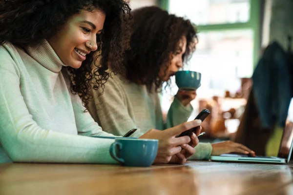 Nahaufnahme von zwei glücklichen afrikanischen Freundinnen, die im Café sitzen — Stockfoto