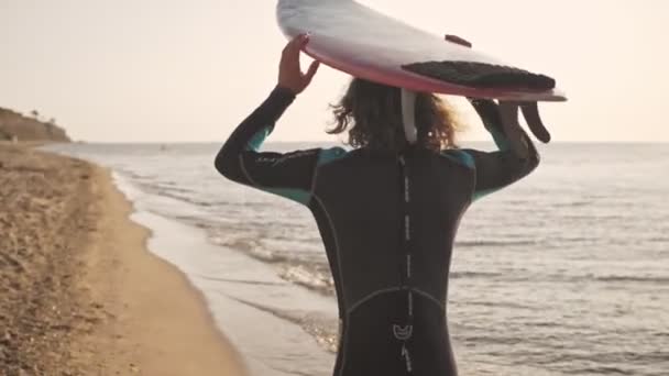 Widok Tyłu Przystojnego Młodzieńca Niesie Deskę Surfingową Plaży — Wideo stockowe